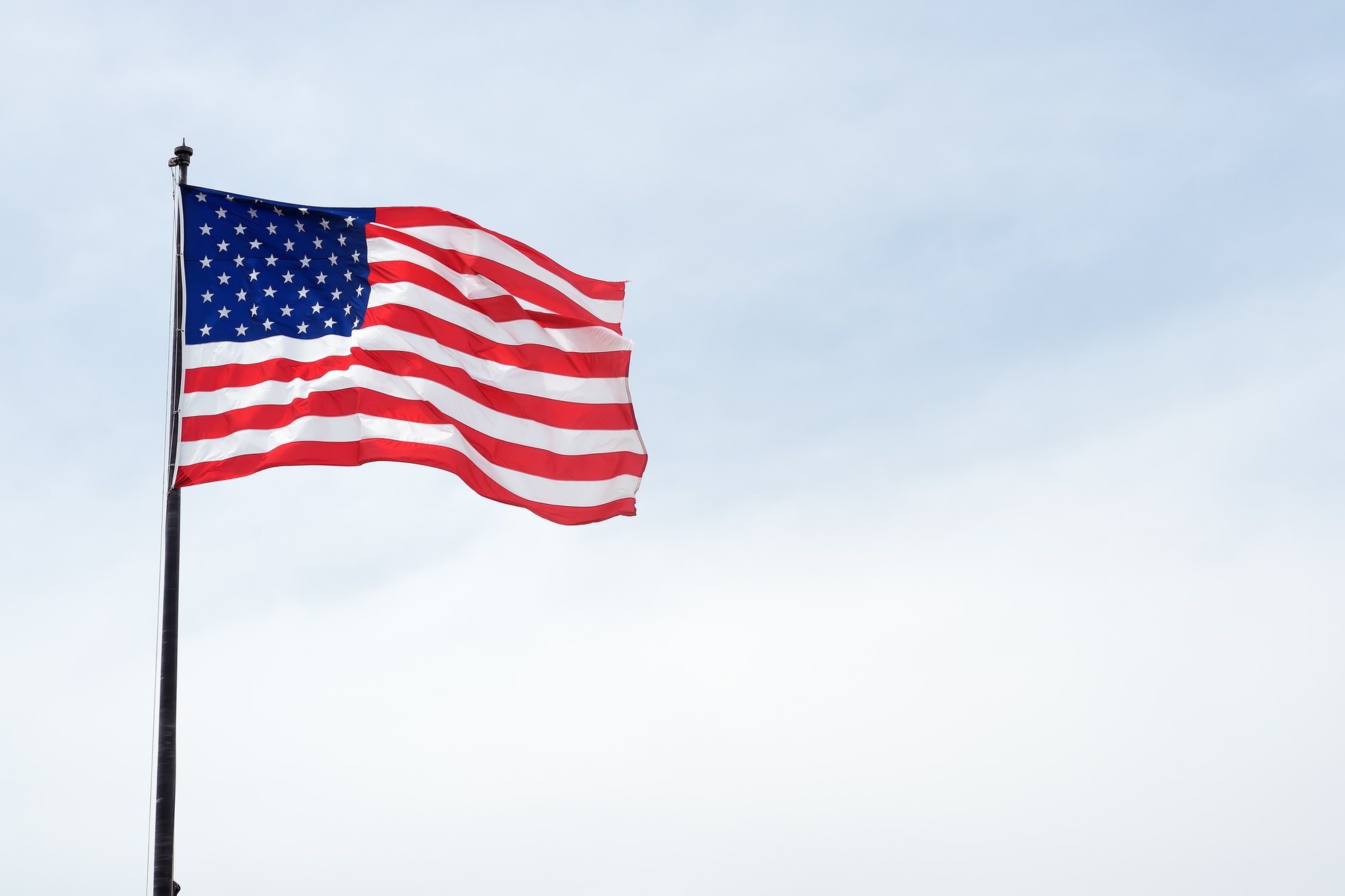 USA flag on blue sky. The star-spangled American flag. Travel, tourism, sightseeing of usa.